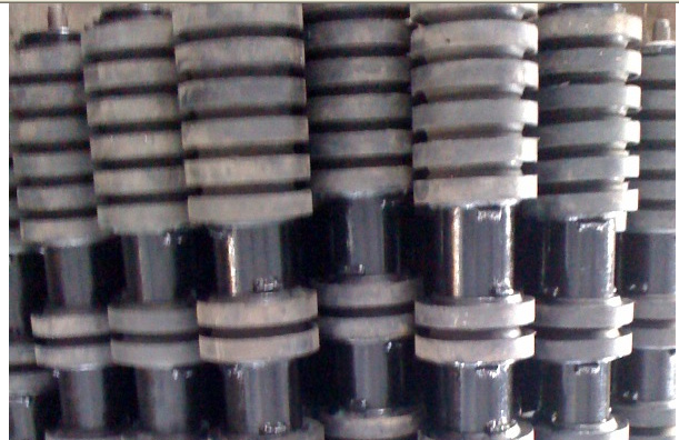 Finished return rollers with rubber rings, stacked in rows in the works. Finished return rollers with rubber rings, stacked in rows in the works.