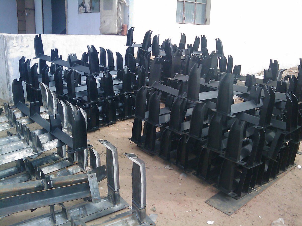 Rows of fabricated idler frames standing on the factory floor, waiting for their rollers. Rows of fabricated idler frames standing on the factory floor, waiting for their rollers.