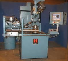 A dynamic balancing machine in the works, with its control panel beside the spindle a pulley is mounted on. A dynamic balancing machine in the works, with its control panel beside the spindle a pulley is mounted on.