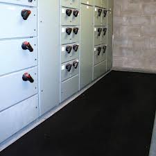 Black insulating matting laid the length of a switchroom floor, in front of a row of electrical panels. Black insulating matting laid the length of a switchroom floor, in front of a row of electrical panels.
