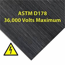 A corner of fine ribbed switchboard matting, marked ASTM D178, 36,000 volts maximum, beside a high voltage warning symbol. A corner of fine ribbed switchboard matting, marked ASTM D178, 36,000 volts maximum, beside a high voltage warning symbol.