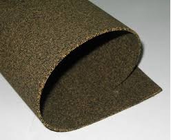 A sheet of rubberised cork curled back on itself, showing the cork granules through its surface. A sheet of rubberised cork curled back on itself, showing the cork granules through its surface.