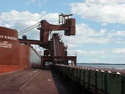 A dockside shiploader conveyor running the length of a quay beside a vessel. A dockside shiploader conveyor running the length of a quay beside a vessel.