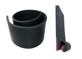 A roll of skirt board rubber beside a cut length standing on end, showing the depth of the strip.