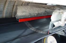 Skirting fitted along the side of a running conveyor, sealing the gap between the belt and the chute.