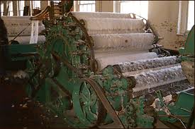 A flat belt driving a carding machine on a mill floor.