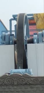 A wide flat belt driving the flywheel of a marble gang saw.