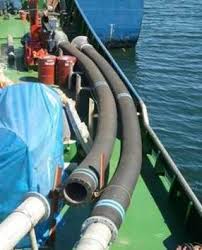 Two armoured suction hoses run over the side of a working barge into the water. Two armoured suction hoses run over the side of a working barge into the water.