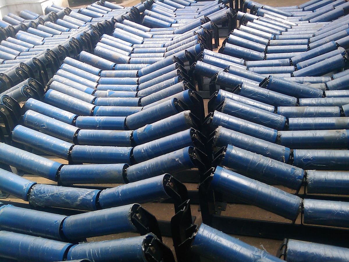 Rows of blue painted idler rollers stacked in their frames on the works floor. Rows of blue painted idler rollers stacked in their frames on the works floor.