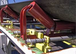 Red idler brackets carrying a conveyor belt, seen from below along the length of the run. Red idler brackets carrying a conveyor belt, seen from below along the length of the run.
