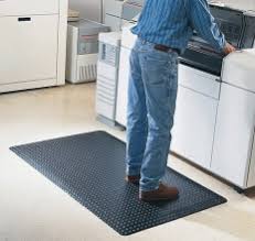 An operator working at a panel while standing on a rubber safety mat. An operator working at a panel while standing on a rubber safety mat.