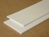Two cut strips of white food grade PVC belt lying one across the other.