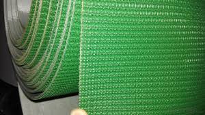 A green rough top belt, its woven grip surface running away from the camera.