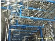 Insulated services pipework running overhead through a plant room.